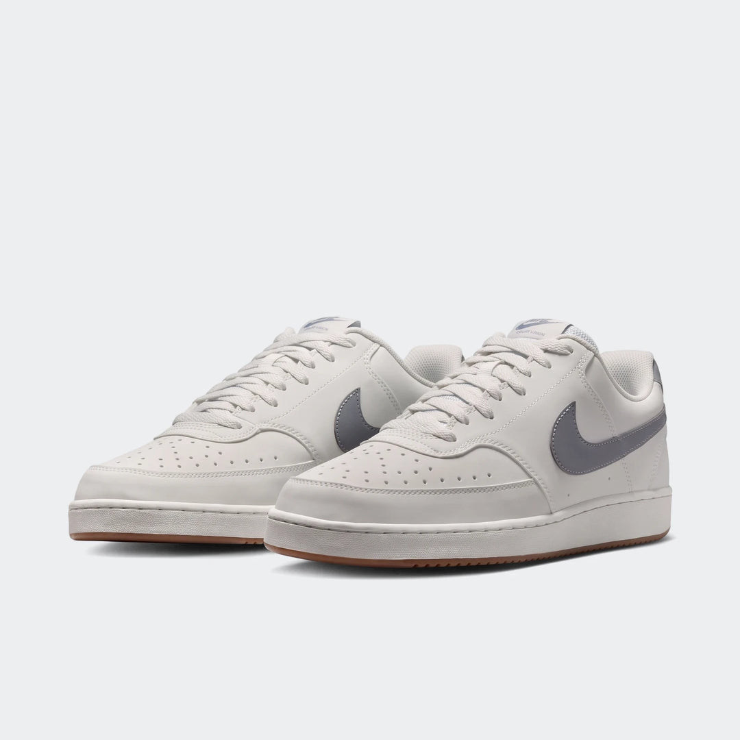 Nike Court Vision Low men's shoes in light gray with dark gray swoosh, shown from a front-right three-quarter view.