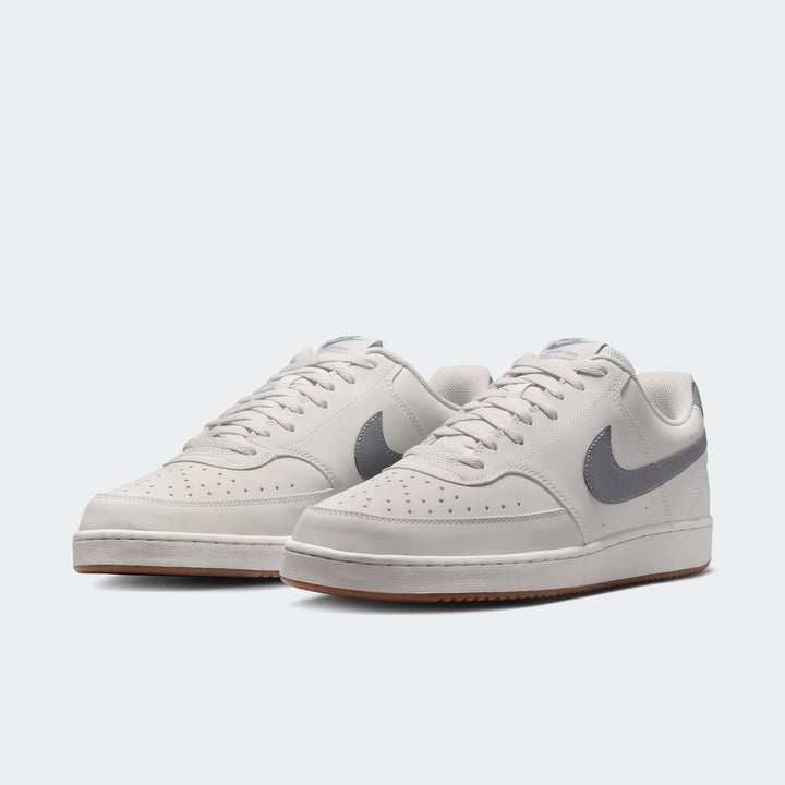Nike Court Vision Low men's shoes in light gray with dark gray swoosh, shown from a front-right three-quarter view.