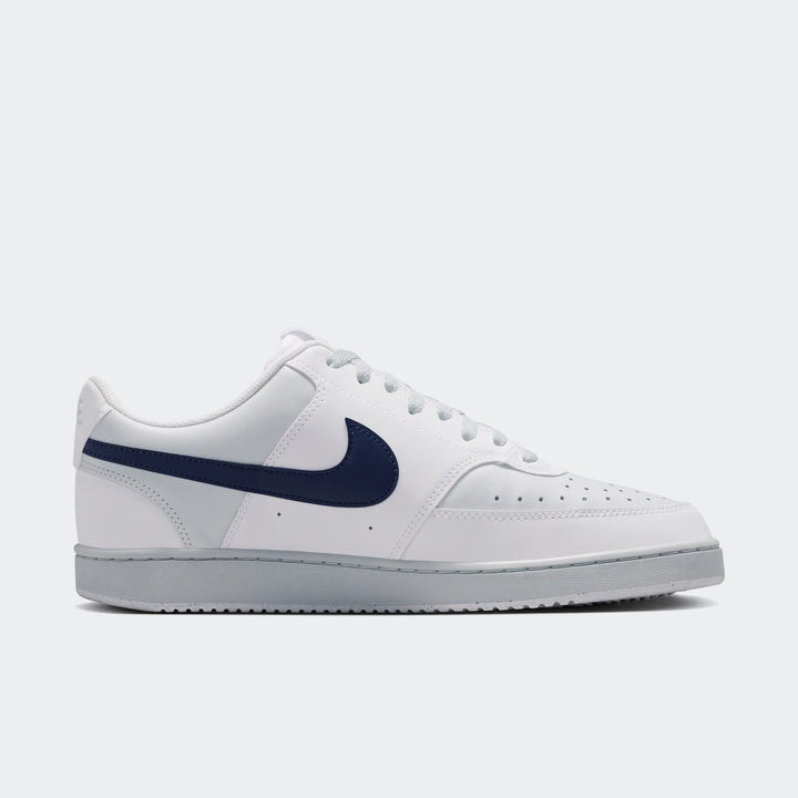 White and navy Nike Court Vision Low men's shoes, featuring a prominent side-view of the iconic swoosh and light gray sole.