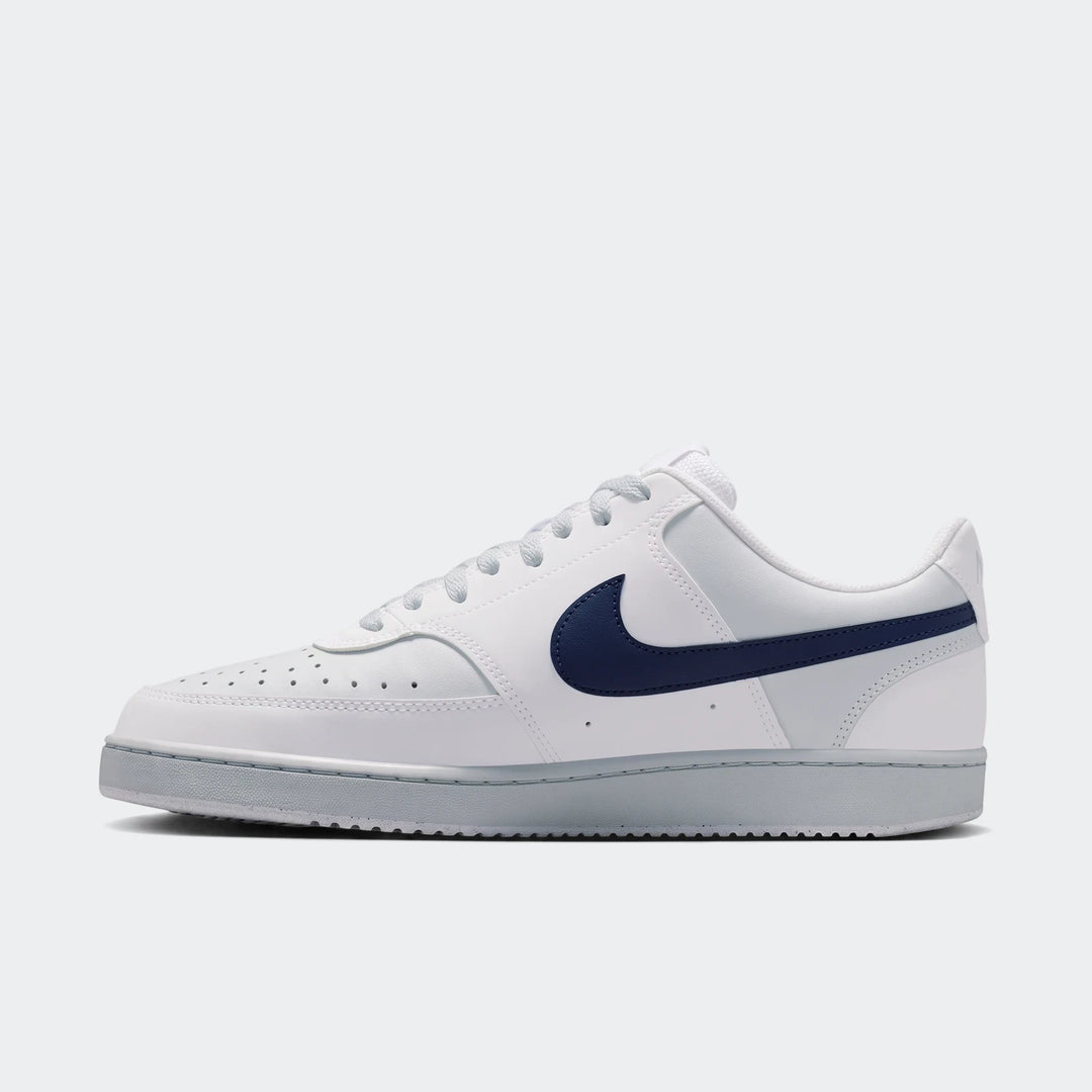 White Nike Court Vision Low Men's Shoes with a navy blue swoosh and grey sole, viewed from the side.