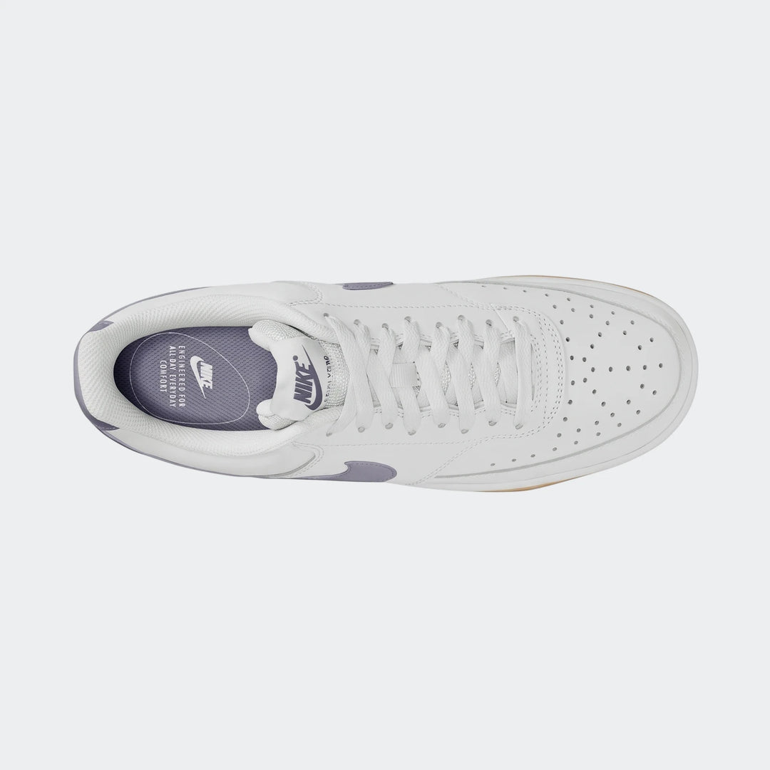 Top-down view of white Nike Court Vision Low men's shoes with subtle purple accents, featuring laces and a durable sole.