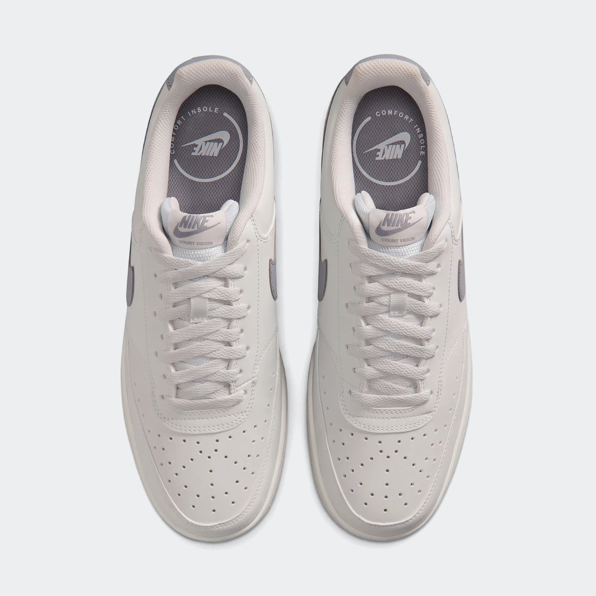Top-down view of white Nike Court Vision Low men's shoes with gray accents, perforated toe box, and white laces.