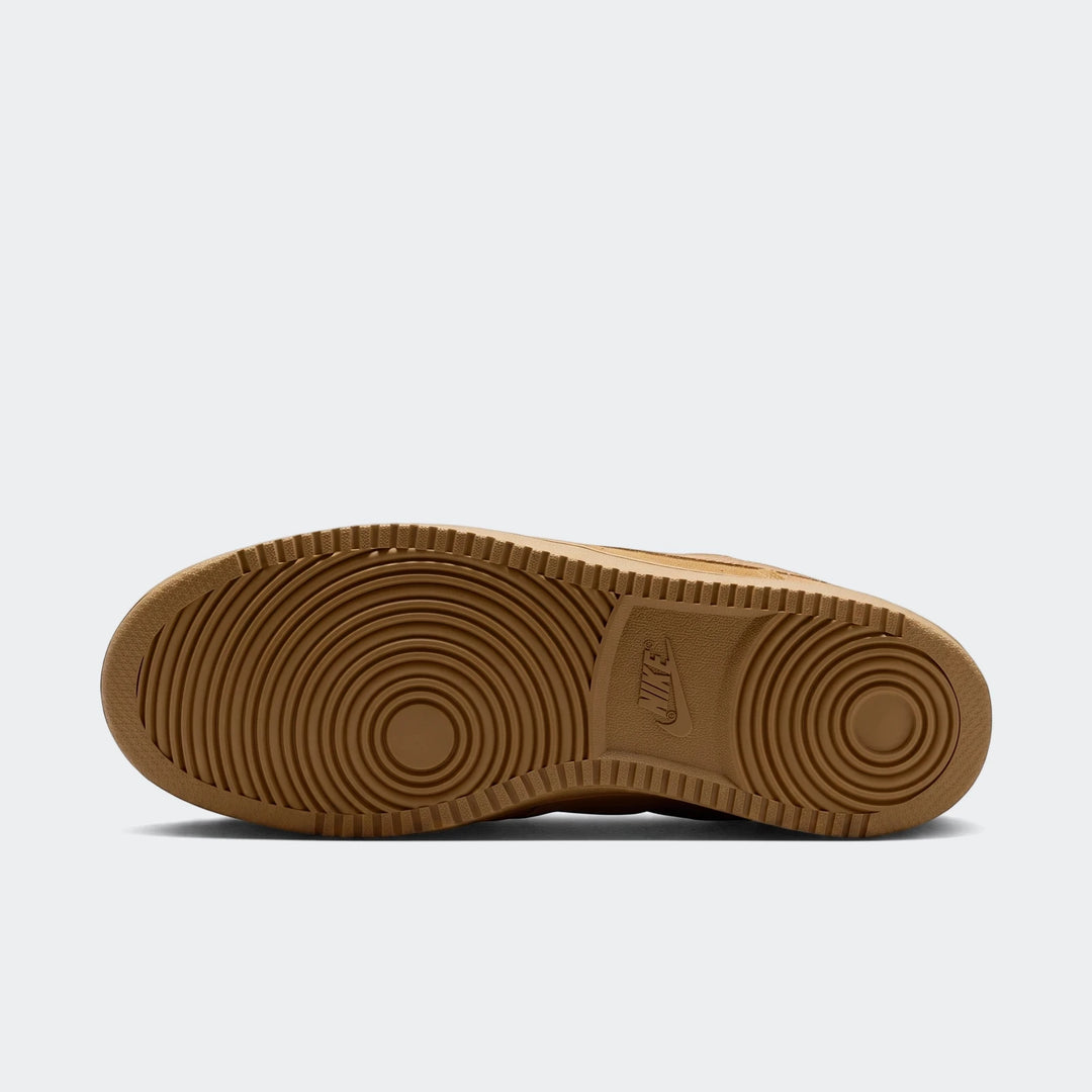 Bottom view of tan Nike Court Vision Low Suede Premium men's shoe, showcasing the circular tread pattern on the rubber