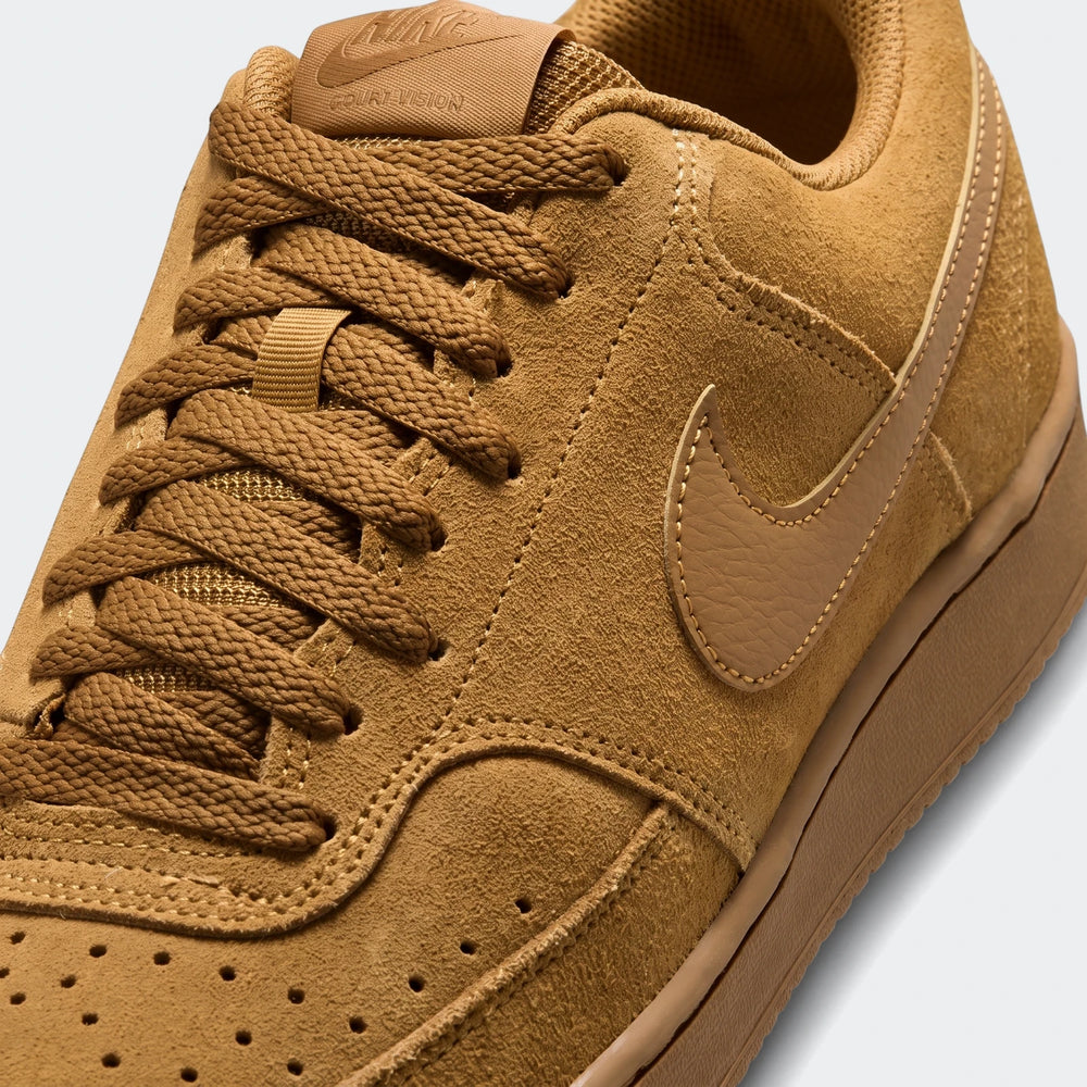Close-up of a brown suede Nike Court Vision Low Premium men's shoe, showcasing its laces, textured upper, and distinctive