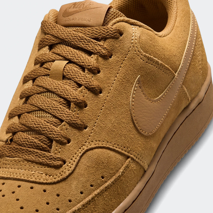 Close-up of a brown suede Nike Court Vision Low Premium men's shoe, showcasing its laces, textured upper, and distinctive
