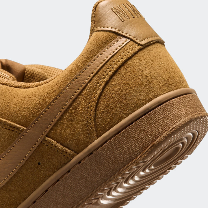 Close-up view of a tan suede Nike Court Vision Low Suede Premium men's shoe, highlighting the heel and side detailing.