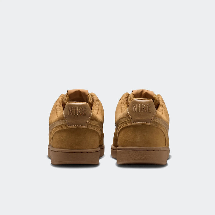 Rear view of two Nike Court Vision Low Suede Premium men's shoes in brown, showcasing the heel tab with Nike branding.