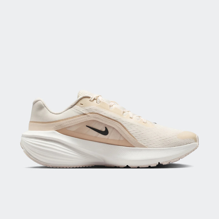 Nike Downshifter 14 men's road running shoe in white and beige, featuring a mesh upper and a distinct wavy white sole, shown