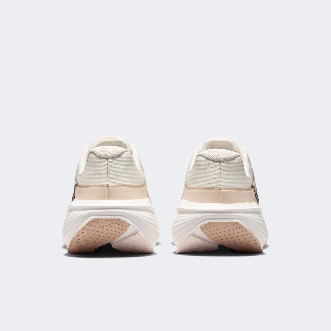 Rear view of Nike Downshifter 14 men's road running shoes in white and beige, showcasing the heel and sole design.
