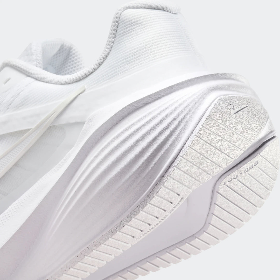 A close-up, rear view of a white Nike Downshifter 14 running sneaker, showcasing the textured heel and sole.