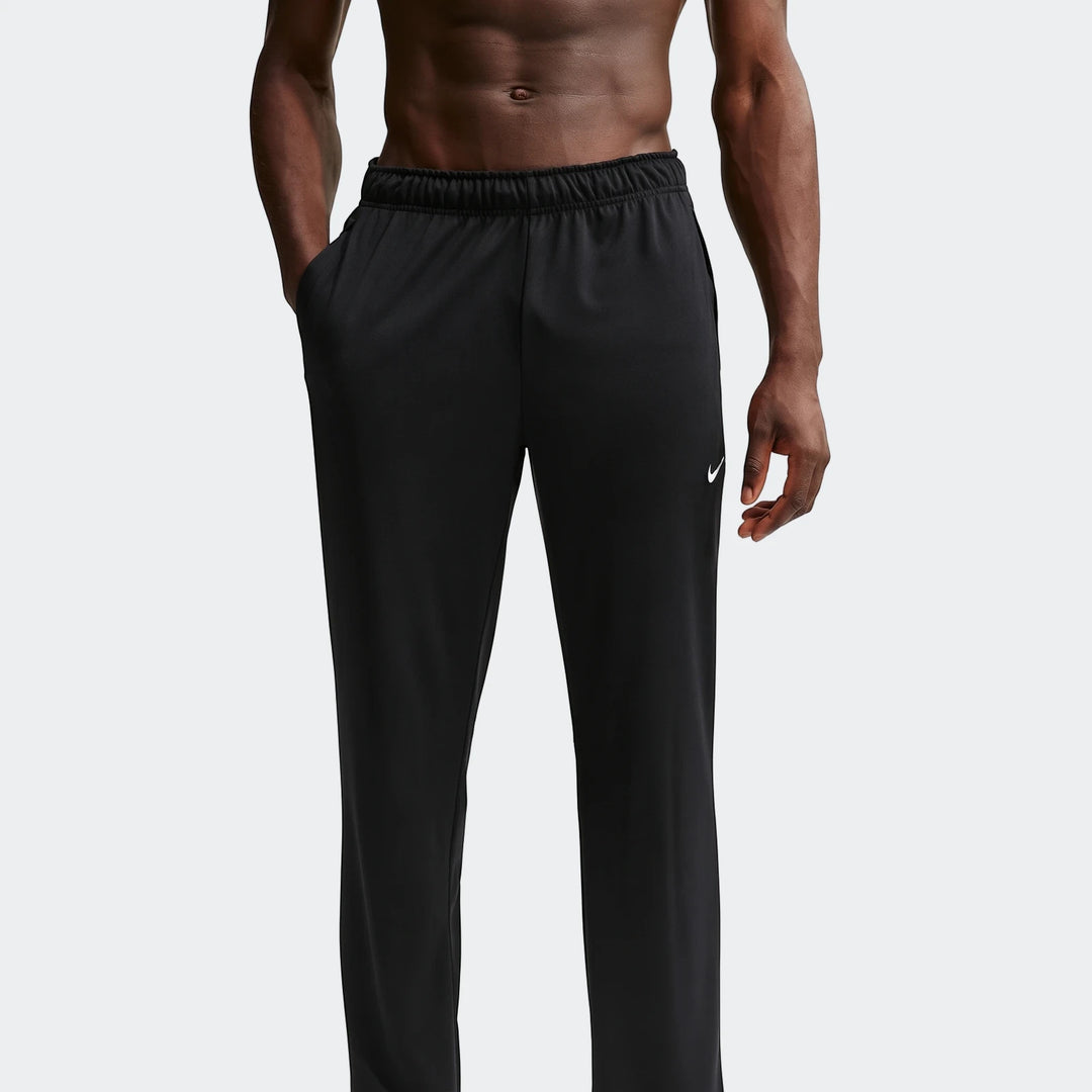 A male model wears black Nike Flex Men's Dri-Fit Pants, showcasing their comfortable, relaxed fit. The athletic pants