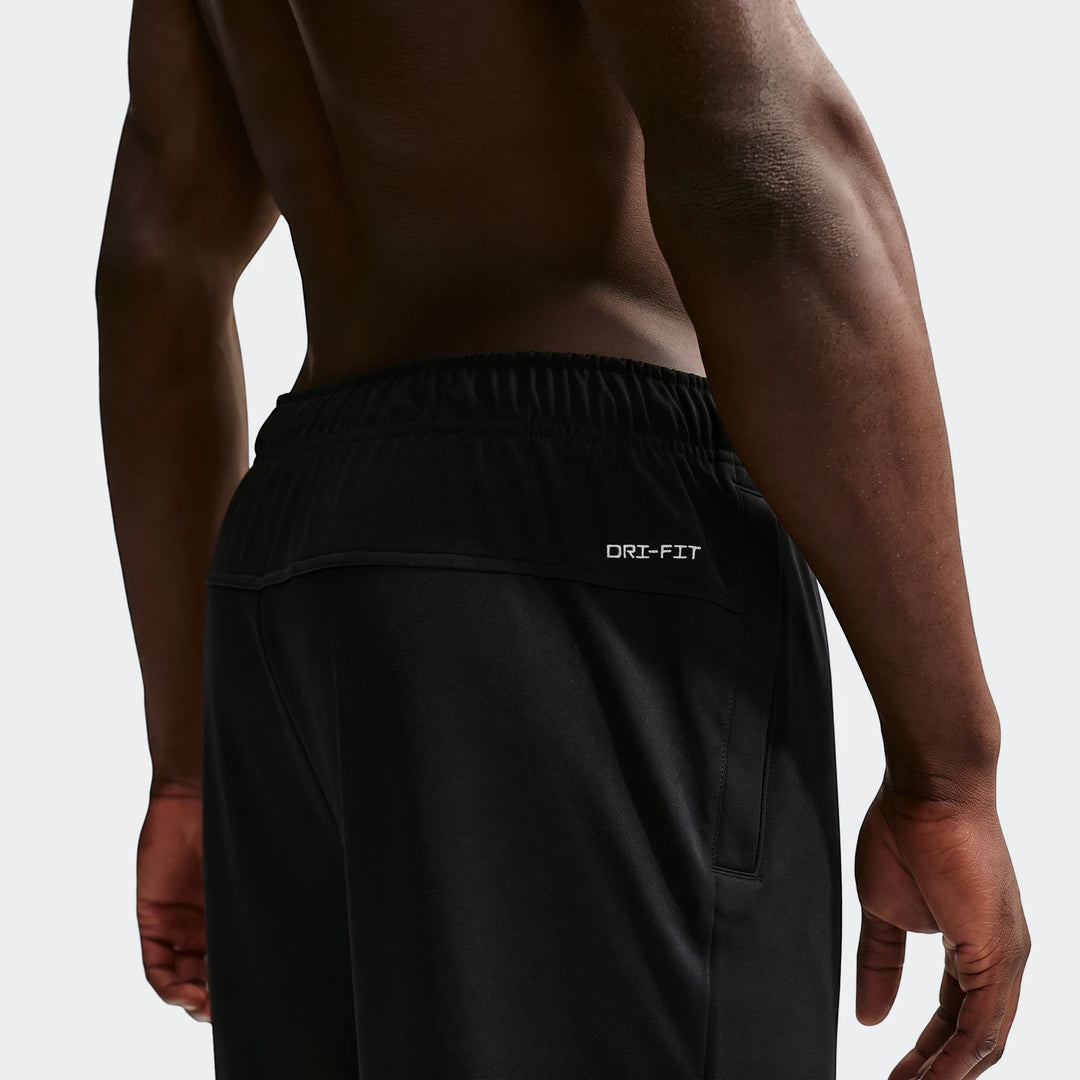 Nike Flex Men's Dri-Fit Pants in black, worn by a man from the back showing the logo and fabric detail.