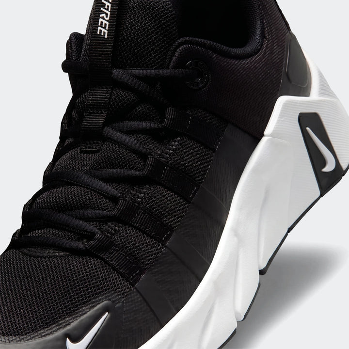 Close-up of a black Nike Free Metcon 7 women's training shoe, showing the mesh upper, white sole, and Nike swoosh.