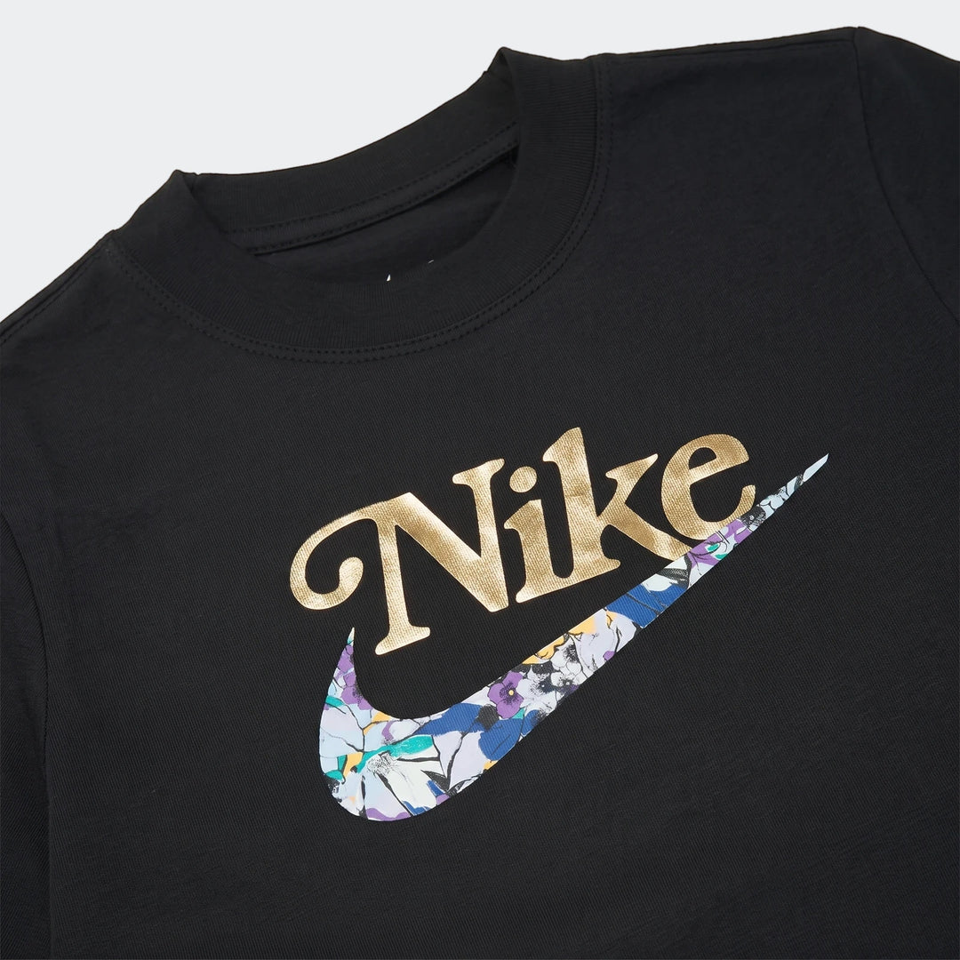 Close-up of a black Nike G Nsw Tee Boxy Vrzty t-shirt featuring a gold Nike logo and a floral pattern on the swoosh.