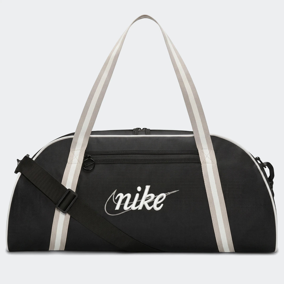 Black Nike Gym Club duffel bag with white Nike script logo and striped handles, featuring an adjustable shoulder strap for