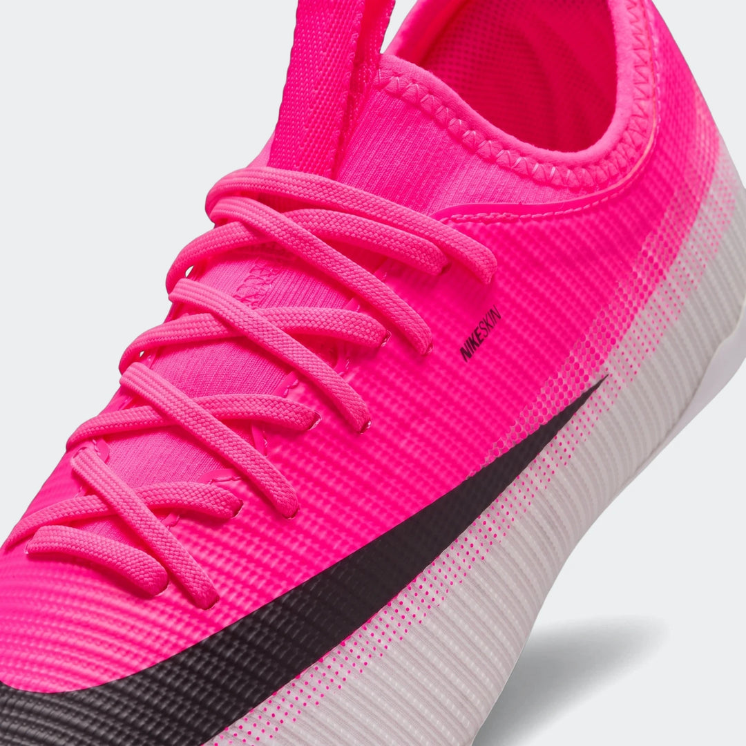 Nike Jr. Mercurial Vapor 17 Academy multi-ground soccer cleat in vibrant pink with a black Nike swoosh, close-up view.