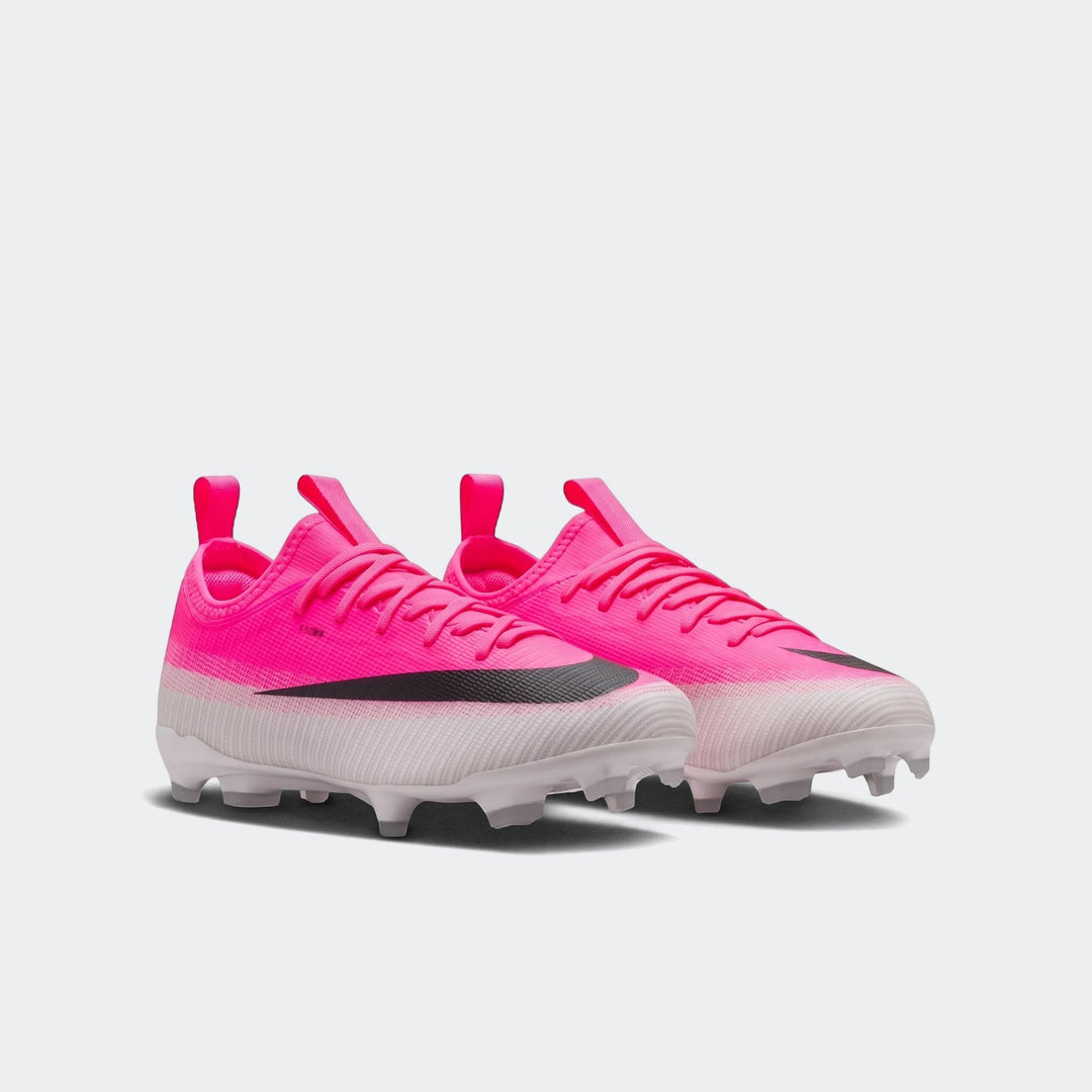 A pair of bright pink Nike Jr. Mercurial Vapor 17 Academy Big Kids' Multi-Ground Low-Top Soccer Cleats with black swooshes