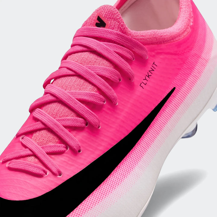 Close-up of a vibrant pink and white Nike Jr. Mercurial Vapor 17 Pro Big Kids' firm-ground low-top soccer cleat.