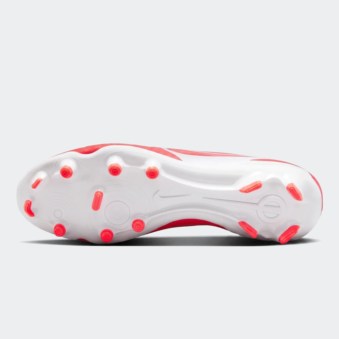 Bottom view of a red and white Nike Legend 10 Club FG/MG football boot, showcasing the white sole and red studs.