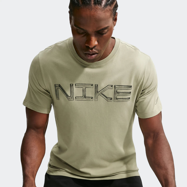 Man wearing an olive green Nike Men's Dri-Fit Training T-Shirt with the outlined Nike logo on the chest.