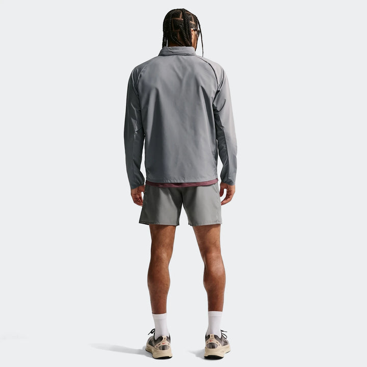 Full body back view of a man wearing a grey Nike Miler Repel UV Protection Running Jacket and matching grey running shorts.