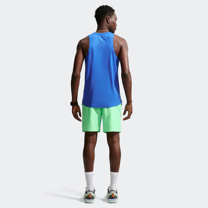 Rear view of a man wearing Nike Miler Men'S Dri-Fit 7" Brief-Lined Running Shorts in light green with a blue tank top and