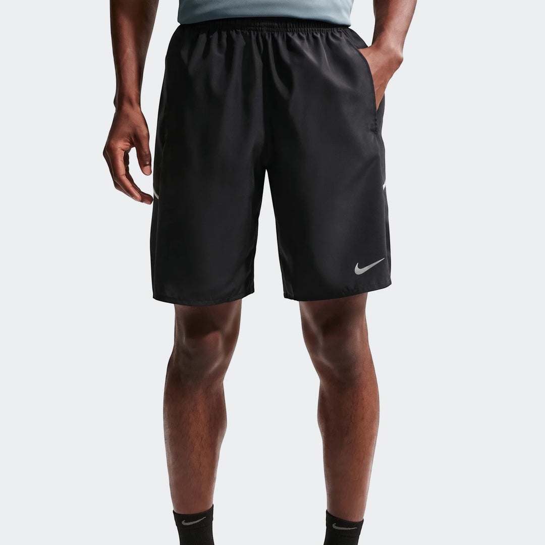 Front view of black Nike Miler Men'S Dri-Fit 9" Unlined Running Shorts worn by a model, featuring a silver Nike swoosh logo.