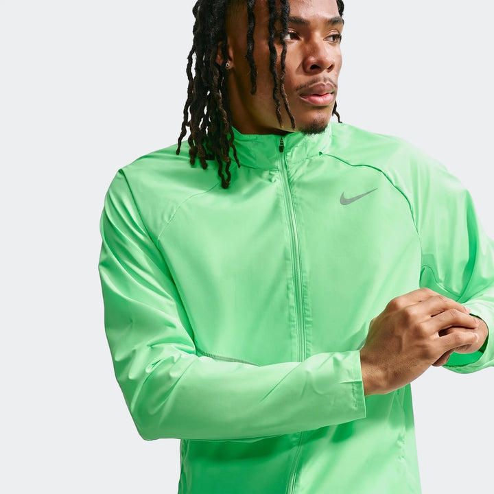 Man wearing a vibrant green Nike Miler Repel UV Protection running jacket with a front zipper, captured in a waist-up studio