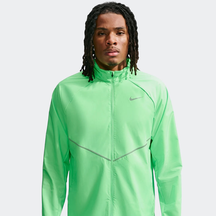 Front view of a man wearing a bright green Nike Miler Repel UV Protection Running Jacket with a reflective zigzag stitch