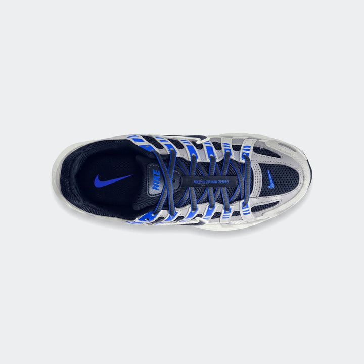 Top-down view of Nike P-6000 Big Kids' Shoes in gray and blue with black laces on a white background.