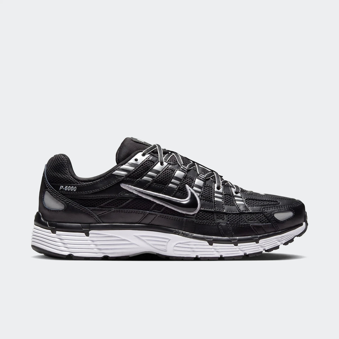 Side view of a black and silver Nike P-6000 running shoe with a white sole, designed for style and comfort.