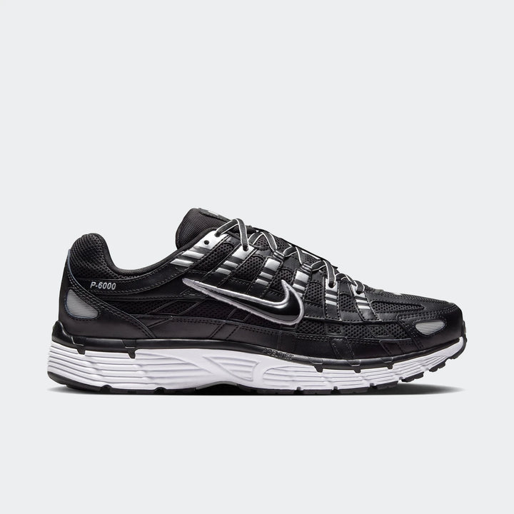 Side view of a black and silver Nike P-6000 running shoe with a white sole, designed for style and comfort.
