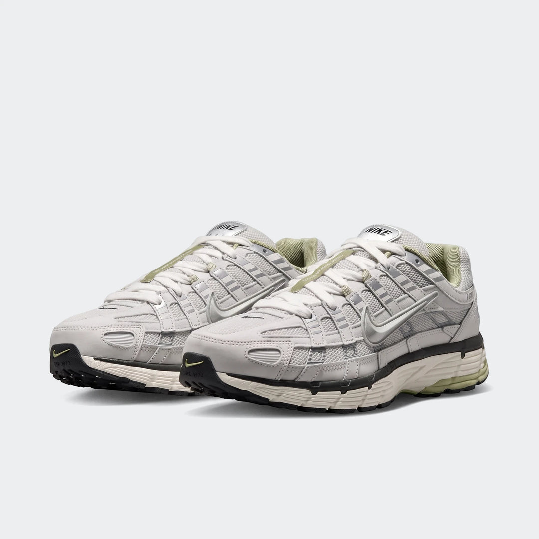 A pair of white and gray Nike P-6000 Men's athletic sneakers with mesh and synthetic overlays, viewed at an angle on a white