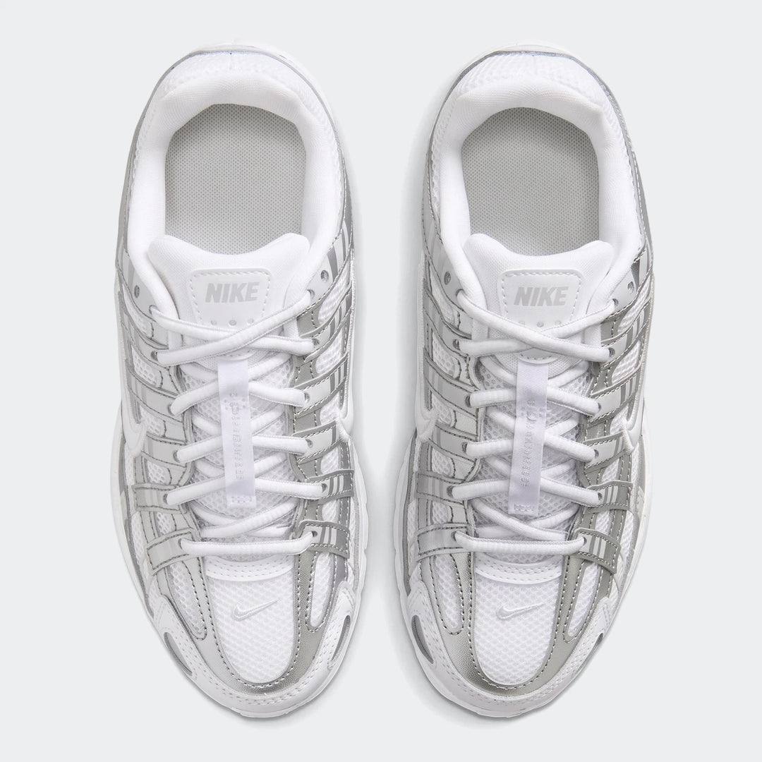 Pair of Nike P-6000 sneakers in white mesh with metallic silver overlays, shown from a top-down view.