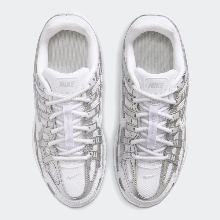 Pair of Nike P-6000 sneakers in white mesh with metallic silver overlays, shown from a top-down view.