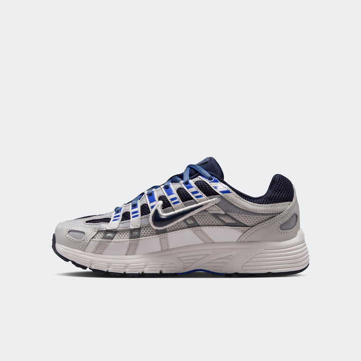 Nike P-6000 Big Kids' Shoes in light gray, white, and blue, featuring mesh and synthetic overlays, shown in a side profile