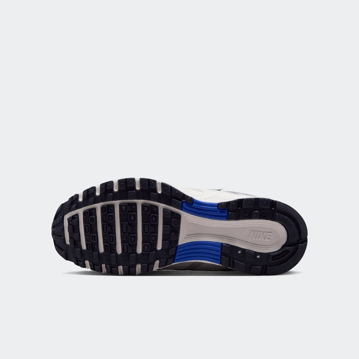 Bottom view of a Nike P-6000 Big Kids' shoe sole, featuring dark blue, grey, and blue traction patterns with a visible Nike