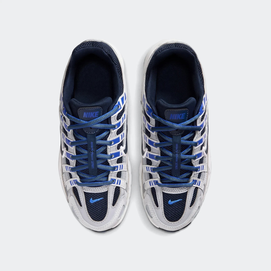 Overhead view of a pair of Nike P-6000 Big Kids' shoes in white, grey, and blue, with blue laces.