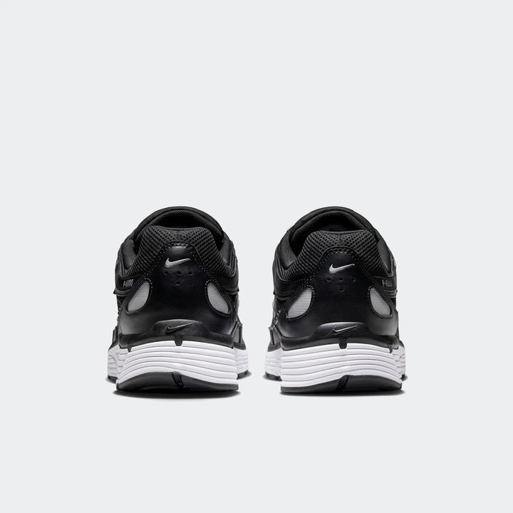 Rear view of Nike P-6000 athletic shoes in black with white soles, showcasing the classic design.
