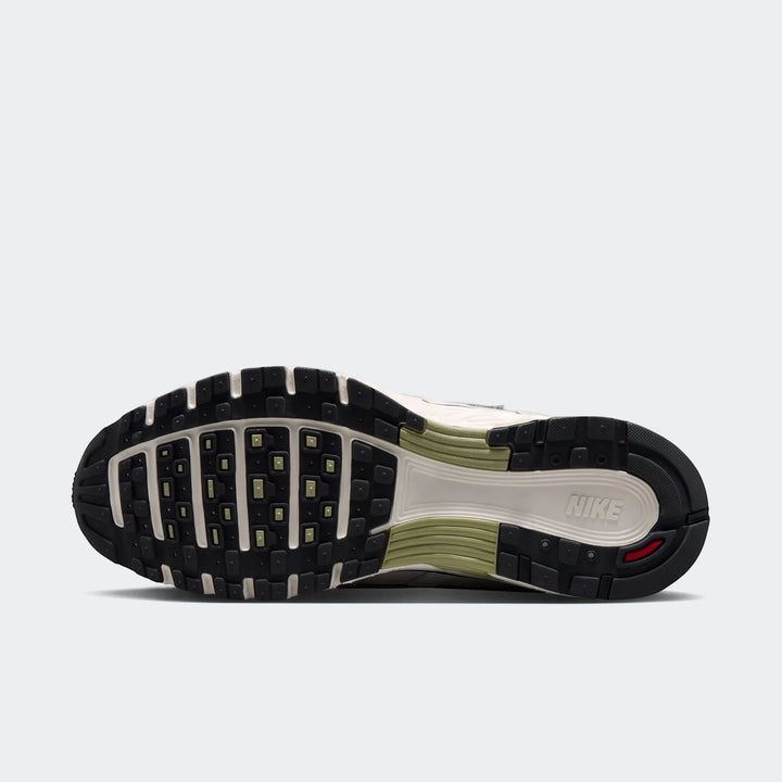 Nike P-6000 men's shoe, bottom view. Features a black lugged outsole, off-white midsole, olive green details, and Nike
