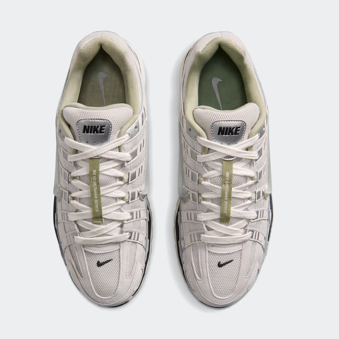 Top-down view of two Nike P-6000 Men's Shoes in light gray and off-white with green accents, perfect for athletic wear.