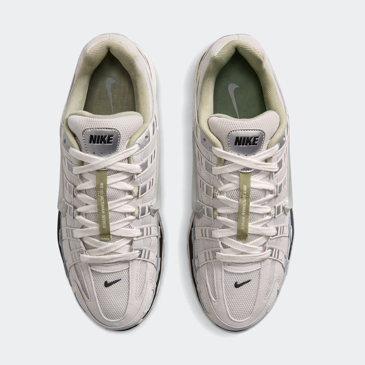 Top-down view of two Nike P-6000 Men's Shoes in light gray and off-white with green accents, perfect for athletic wear.