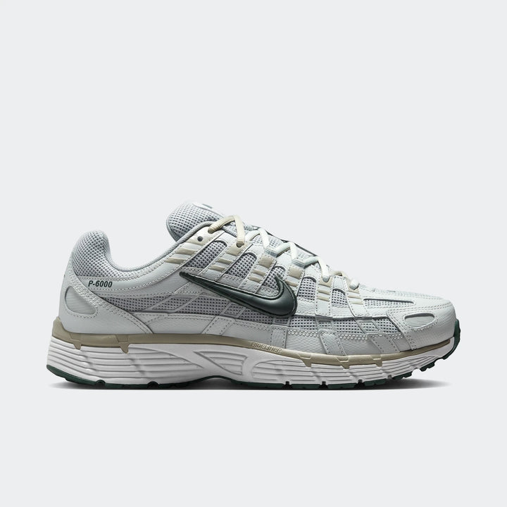 Nike P-6000 Men's Shoes in light grey and dark green, featuring a mesh upper and white sole, viewed from the side.