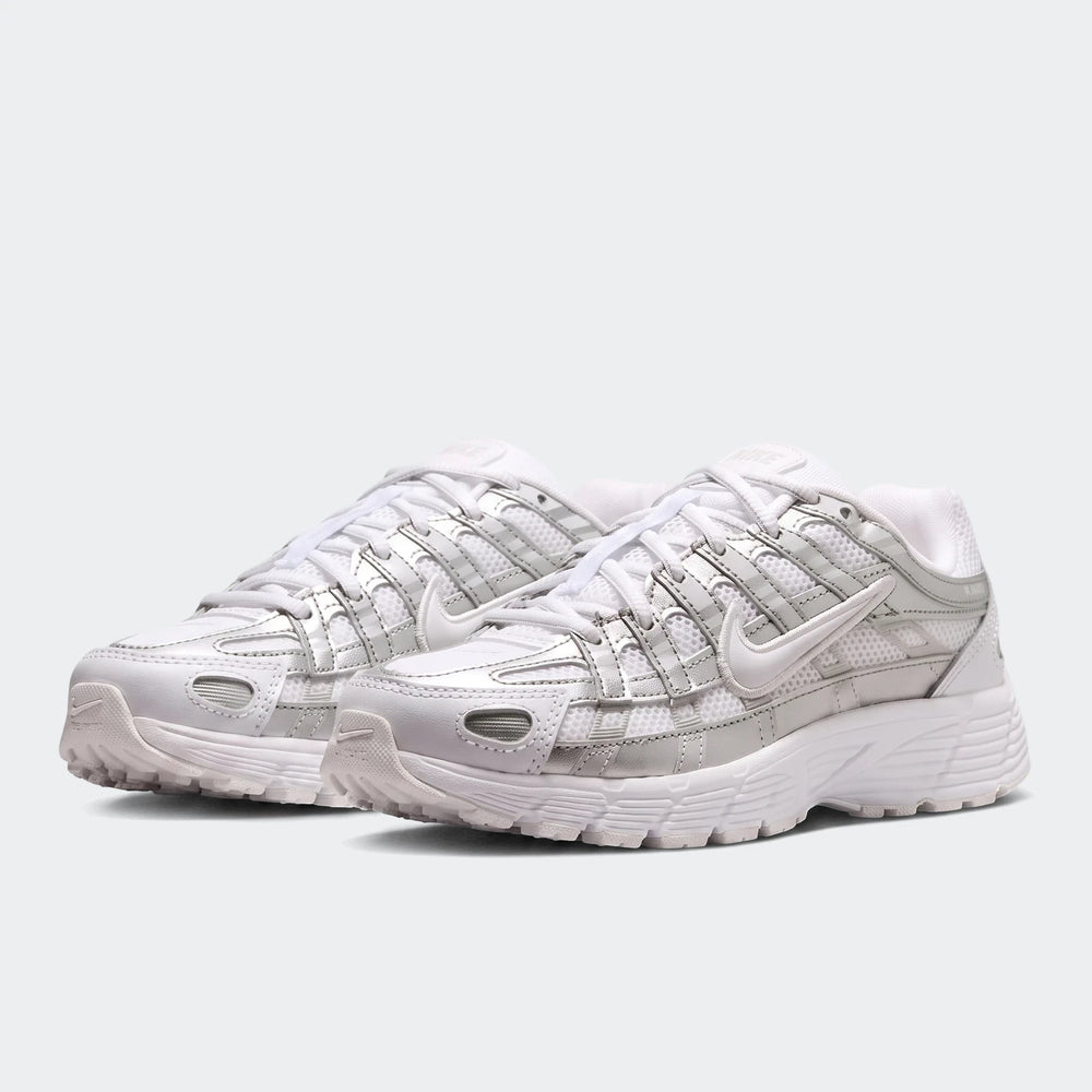 A pair of white and silver Nike P-6000 running sneakers with mesh and metallic details.