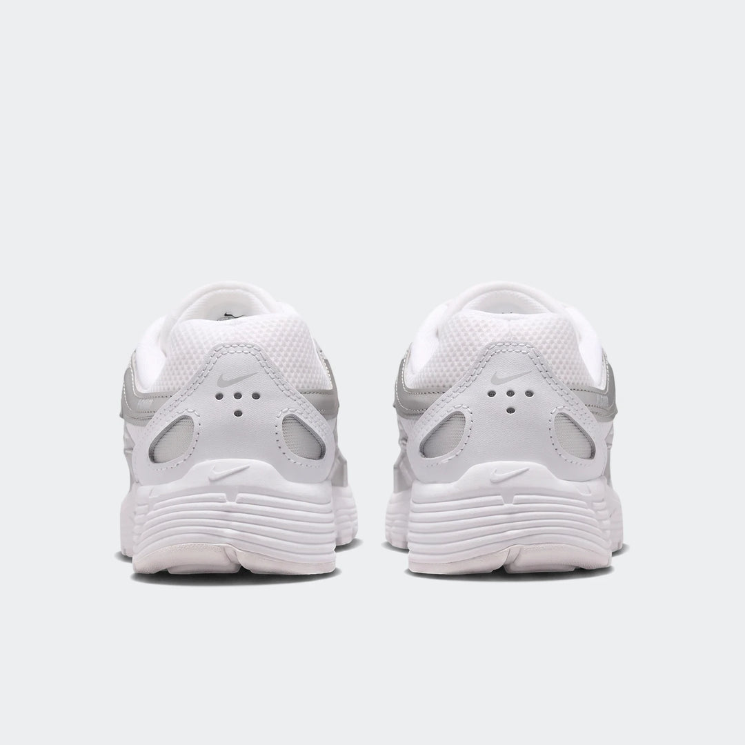 White and silver Nike P-6000 sneakers, seen from the rear, showcasing the detailed heel and sole design.
