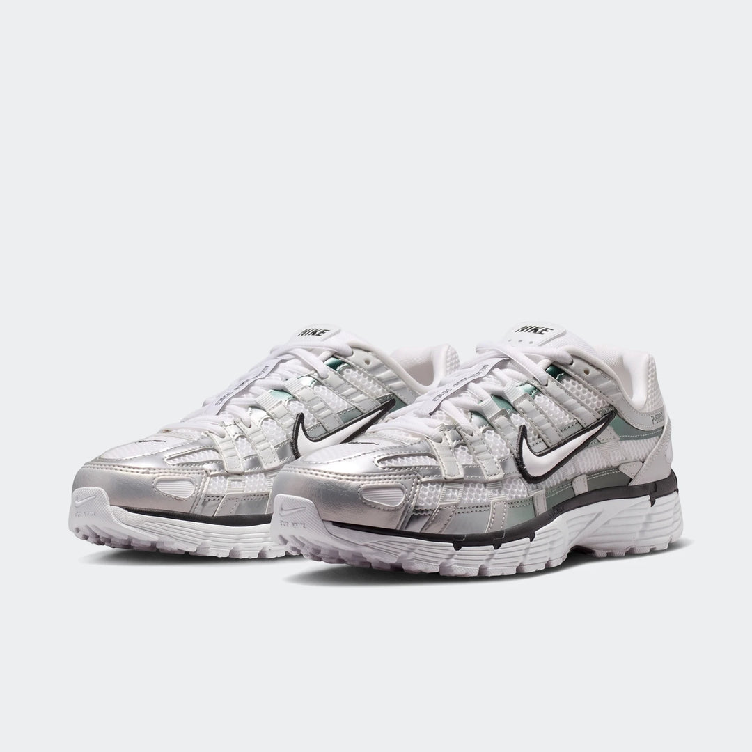 A pair of white and metallic silver Nike P-6000 Women's Shoes with mesh and synthetic overlays, showcased from a slightly