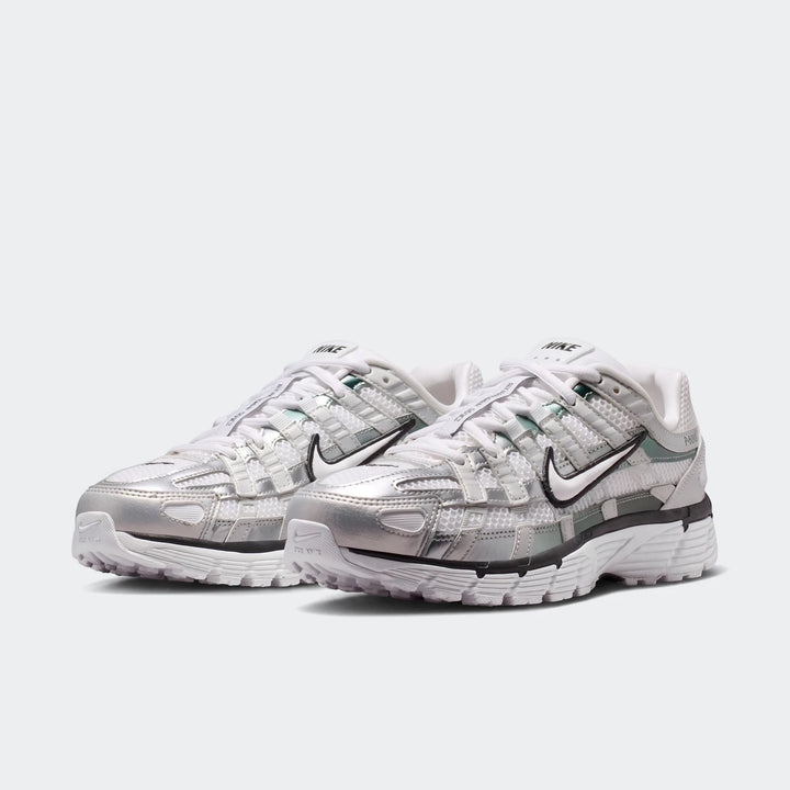 A pair of white and metallic silver Nike P-6000 Women's Shoes with mesh and synthetic overlays, showcased from a slightly