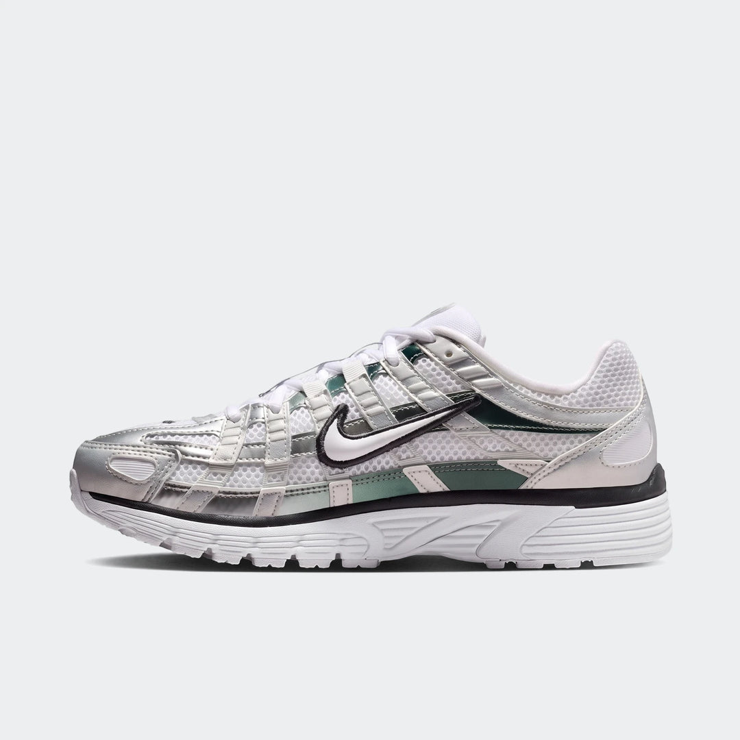 Nike P-6000 Women's Shoes in white mesh with metallic silver overlays, black trim, and green accents. A side view of the