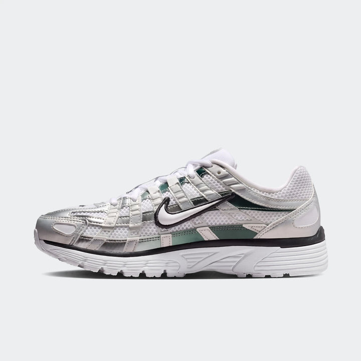 Nike P-6000 Women's Shoes in white mesh with metallic silver overlays, black trim, and green accents. A side view of the