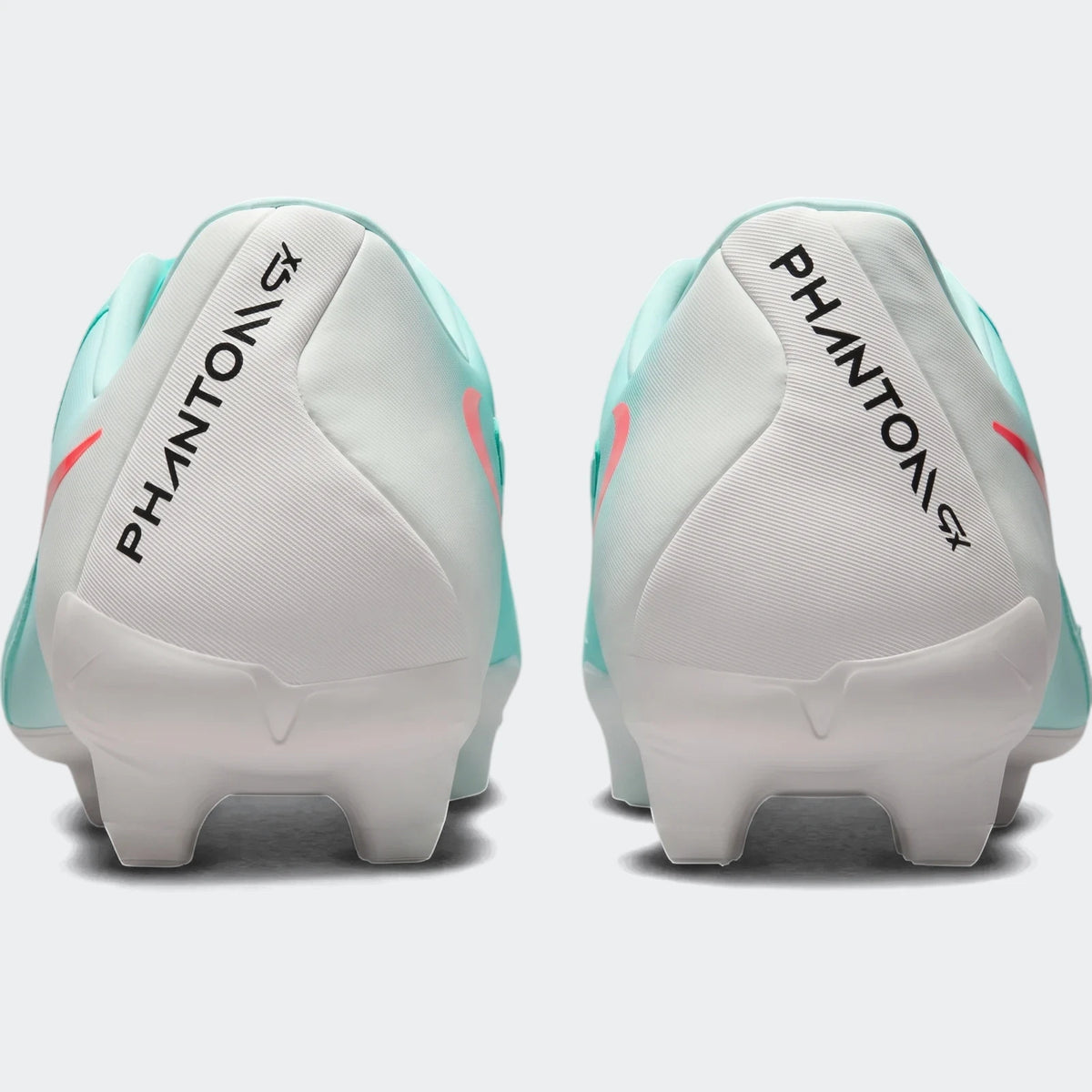 Rear view of two Nike Phantom Gx 11 Academy Fg/Mg green soccer cleats with white heels and coral accents.
